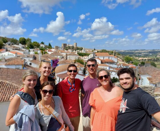 People posing for picture. obidos town bacground